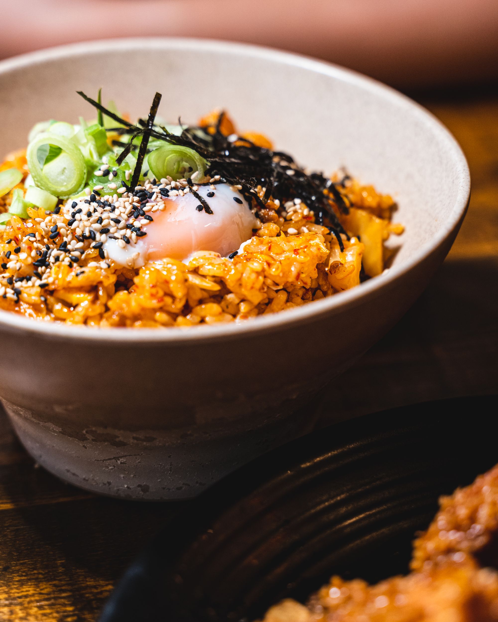 Overhead shot of kimchi fried rice, with a sous vide egg, seaweed and spring onion as garnish