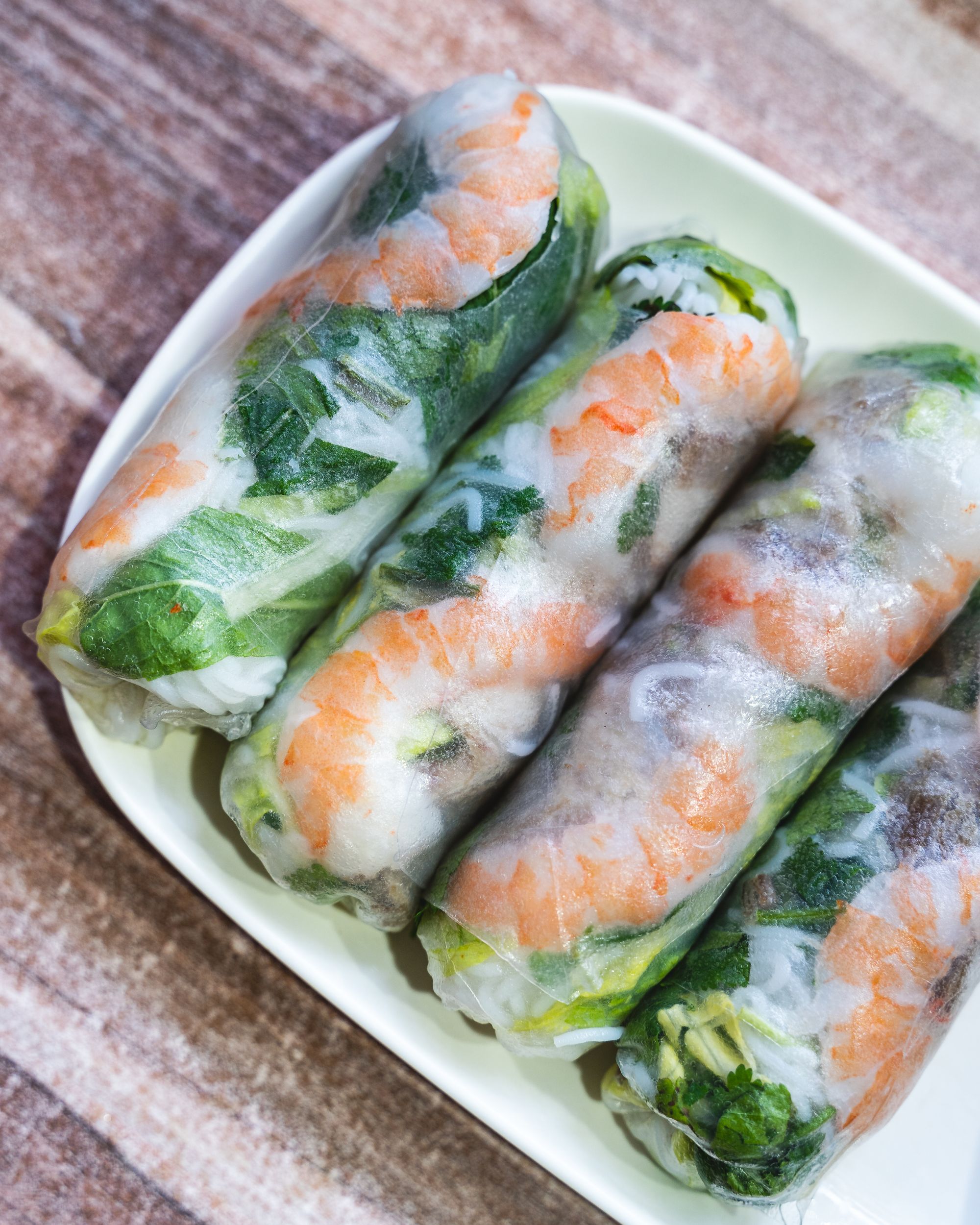 Close up shot of rice paper rolls showing prawn and pork behind the semi transparent rice paper