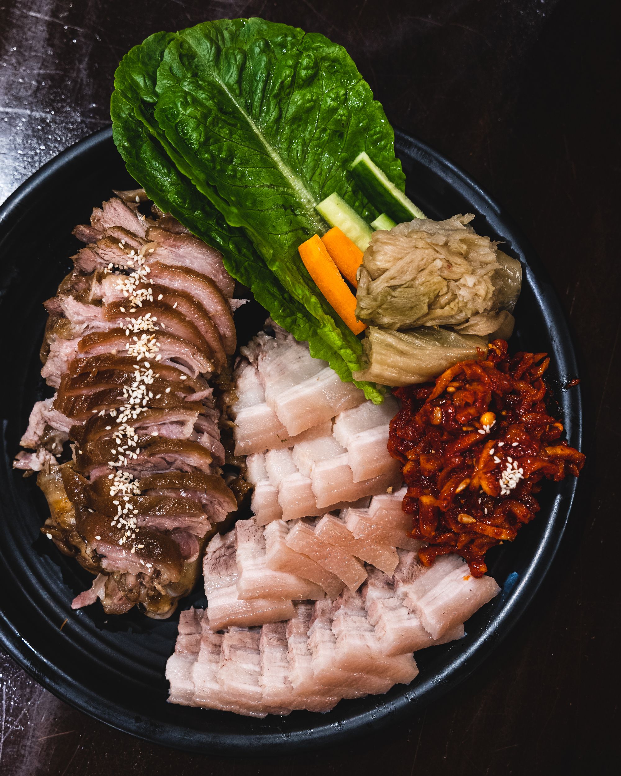 Overhead shot of a pork belly platter, with vegetables