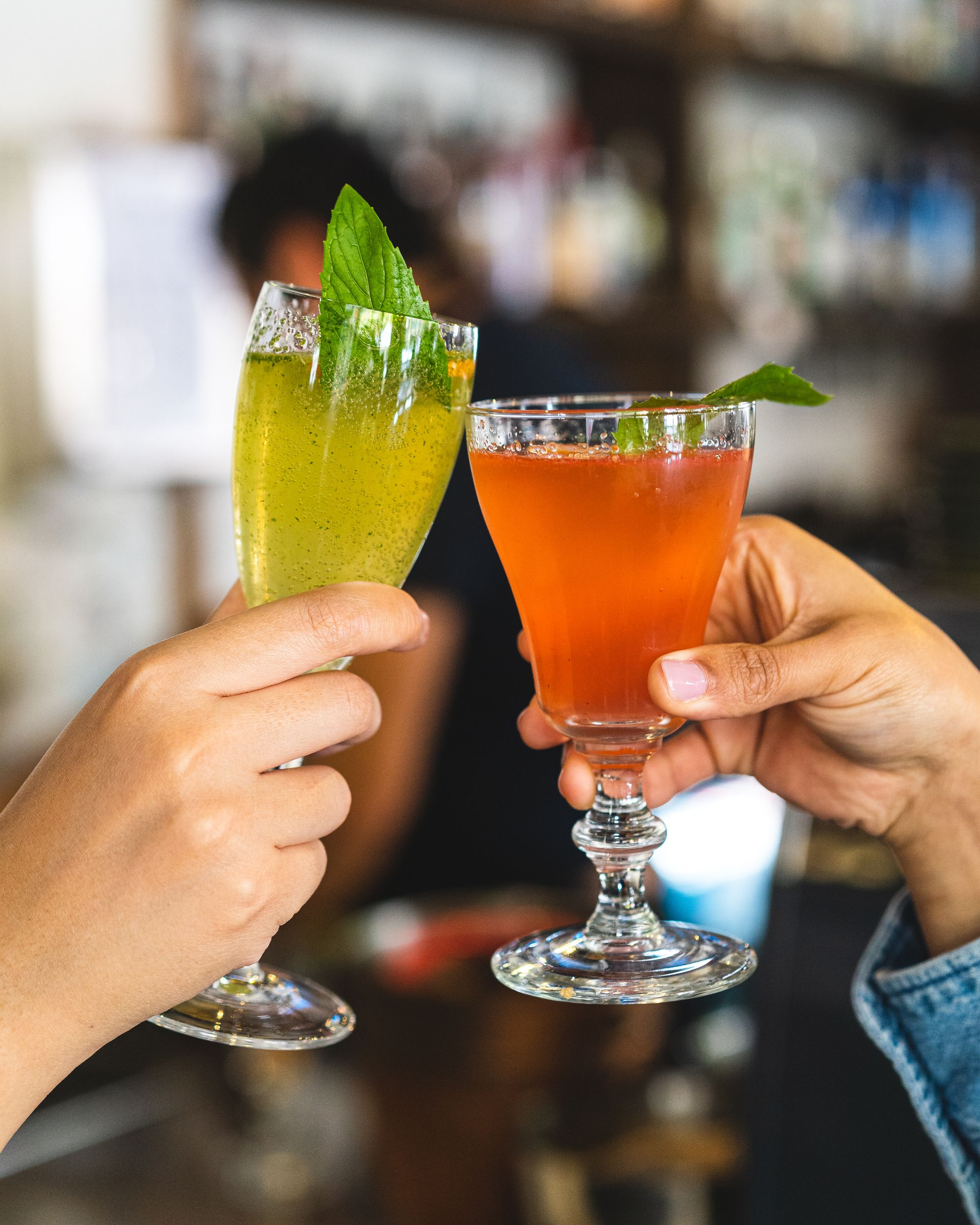 Two hands holding two beverages cheers-ing together