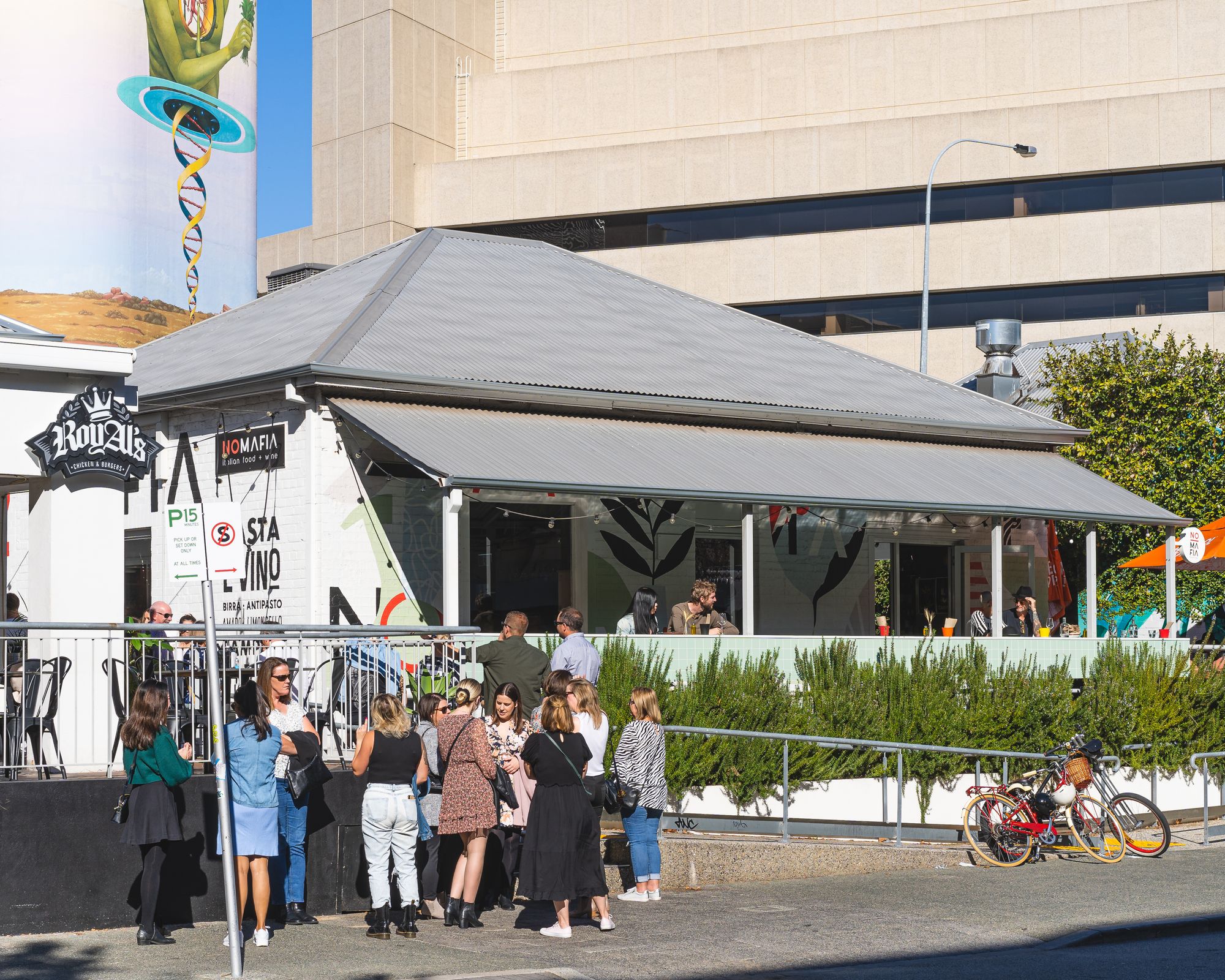 Daytime photo of people lining up to go into No Mafia restaurant