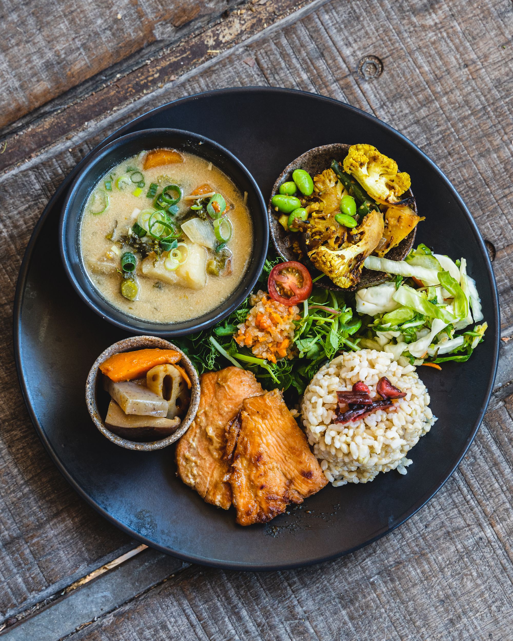 Overhead shot of a plate with many different smaller dishes in smaller bowls