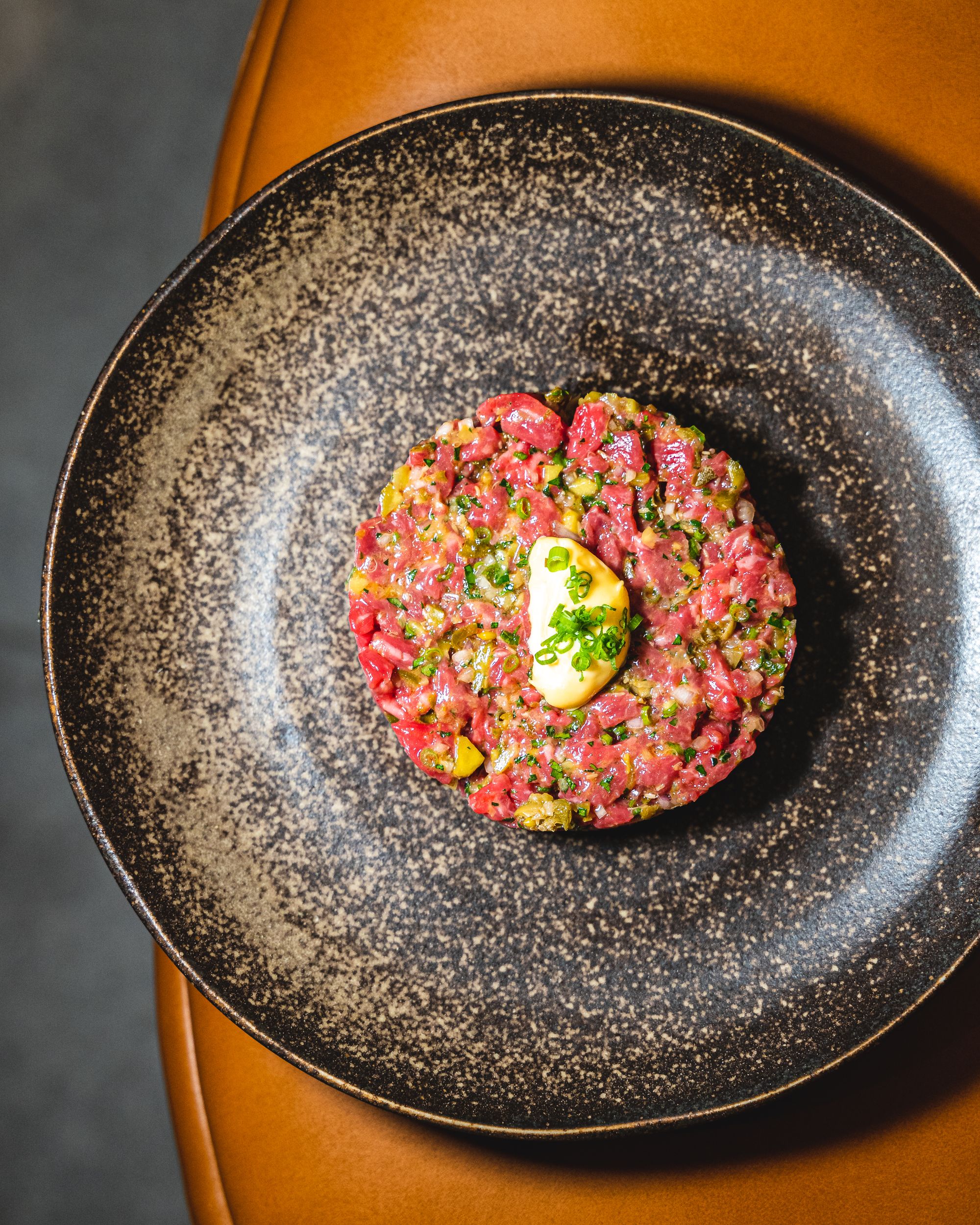 Beef tartare served on a black and bronze plate
