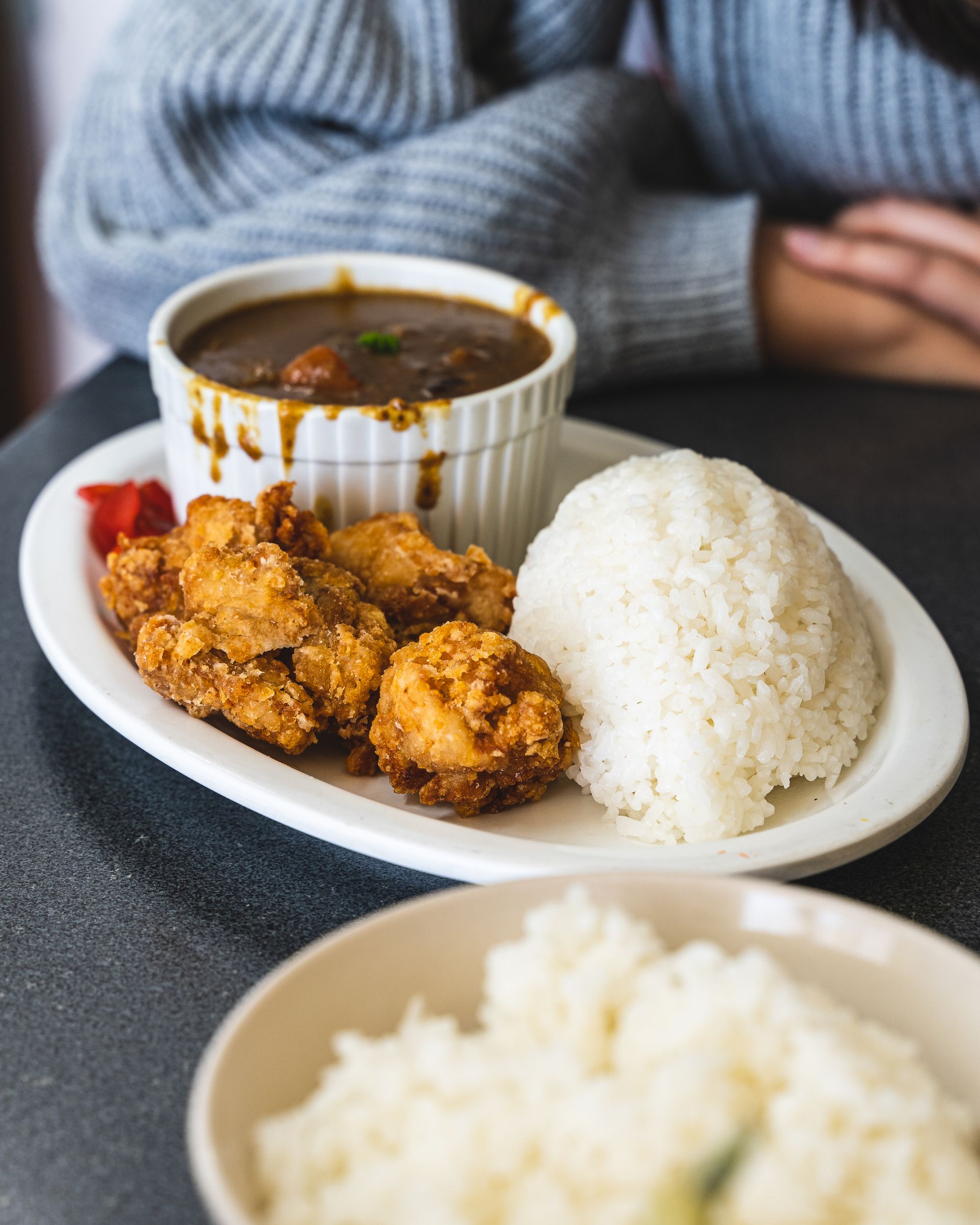 Plate with Japanese rice, karaage on the side and a ramekin with Japanese curry in the back