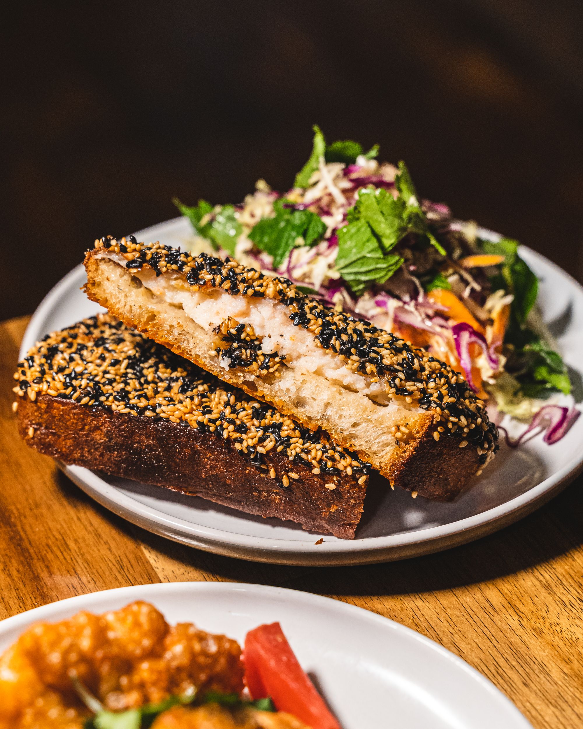 Close up of prawn toast with a colourful salad in the background