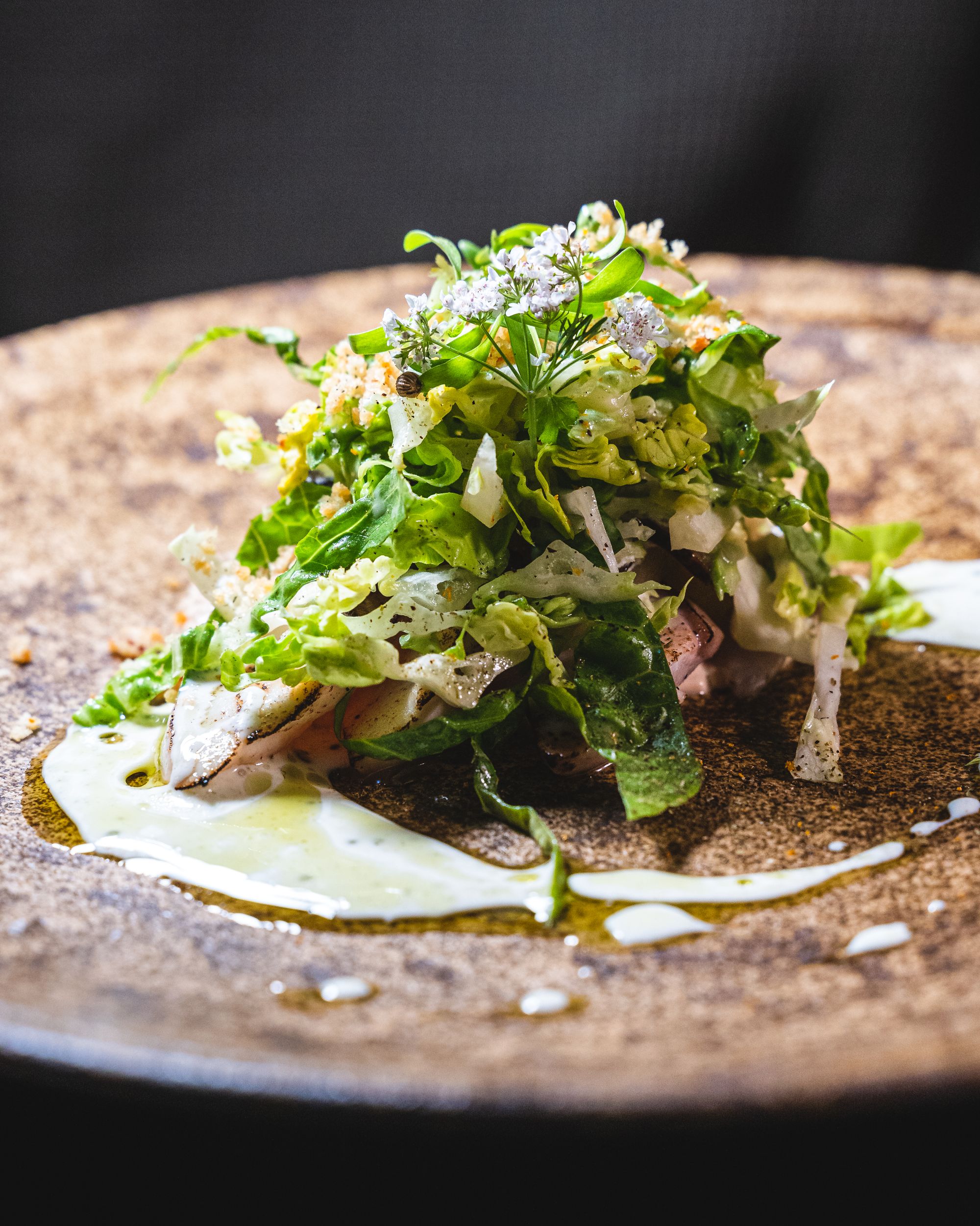 Close up of salad with seared kingfish and flowers as garnish