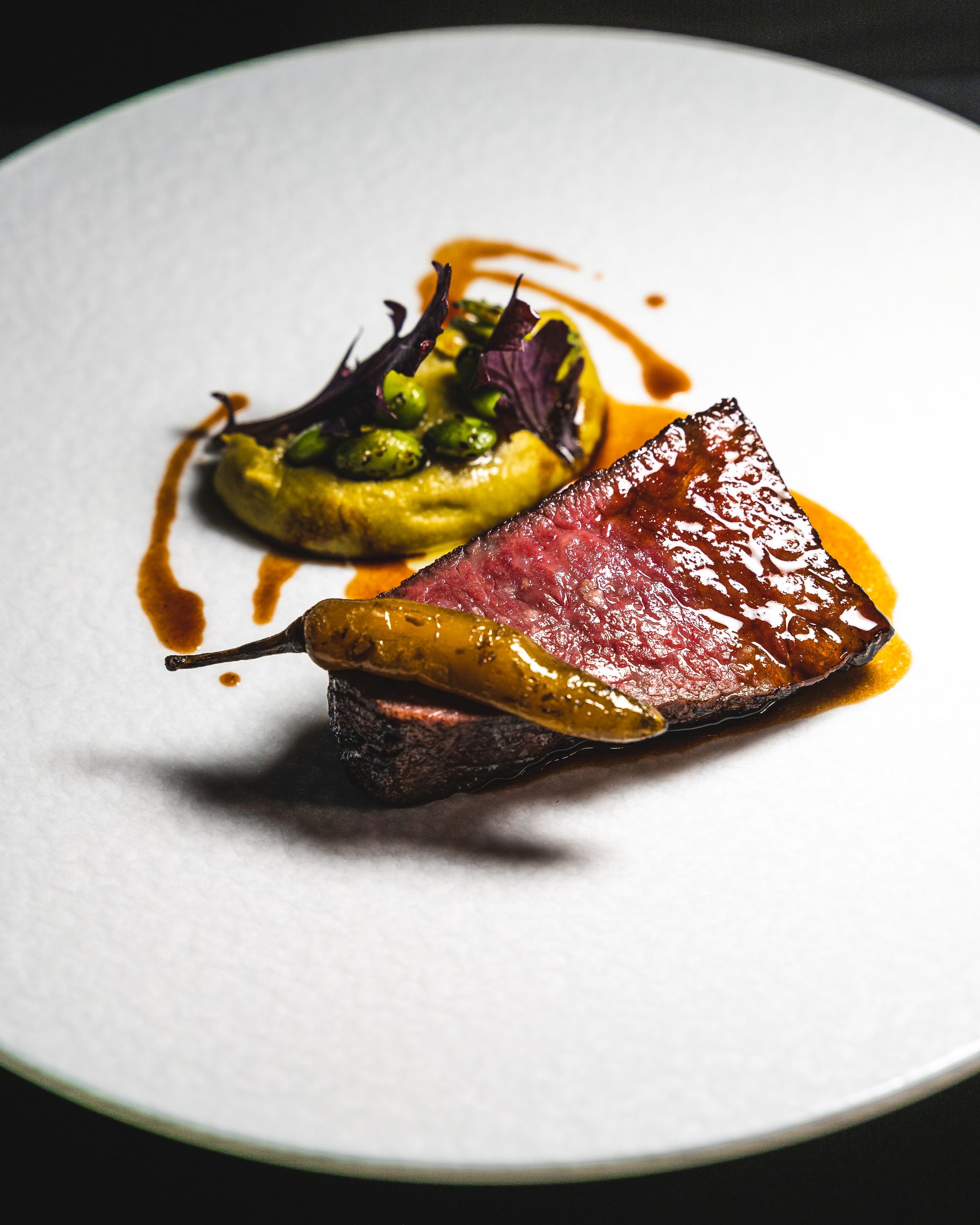 Close up of wagyu steak with puree in the background