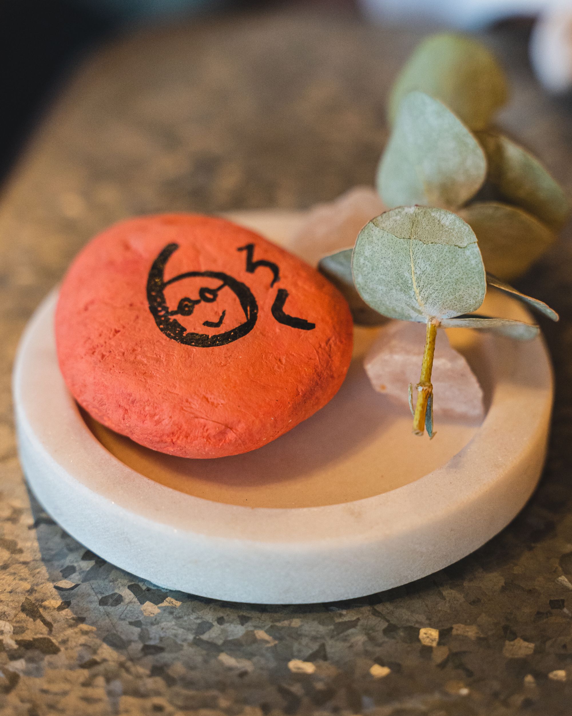 Orange coloured pebble with the number 6 and "roku" written in hiragana