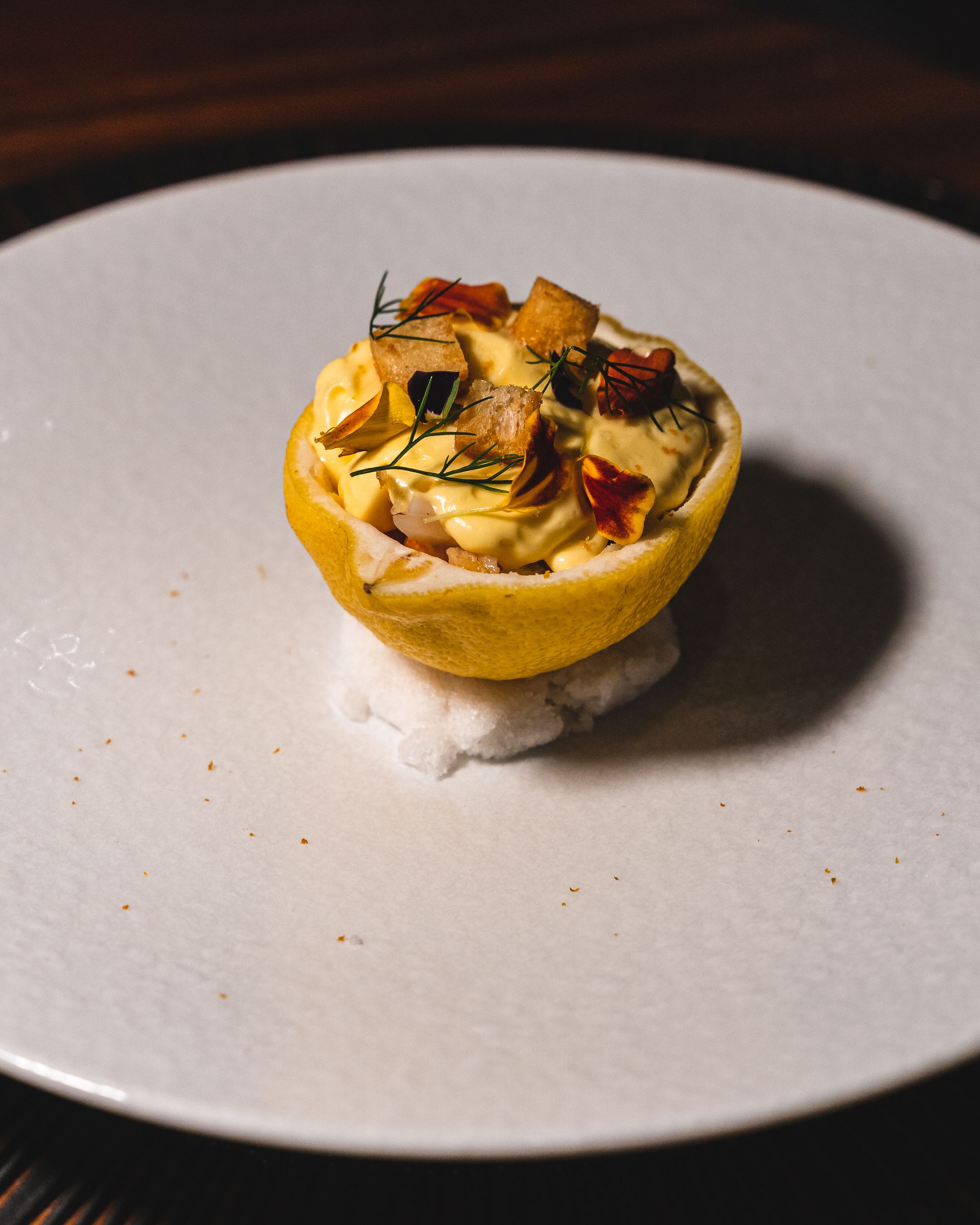 Close up of a lemon with king crab, covered in a buttery sauce 