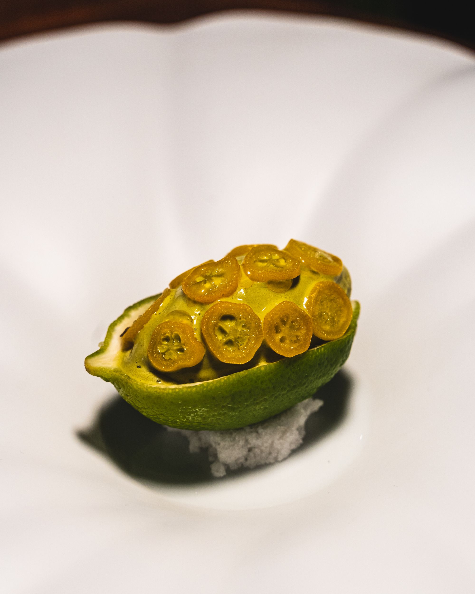 Close up of ice-cream in a lime with kumquat on the top