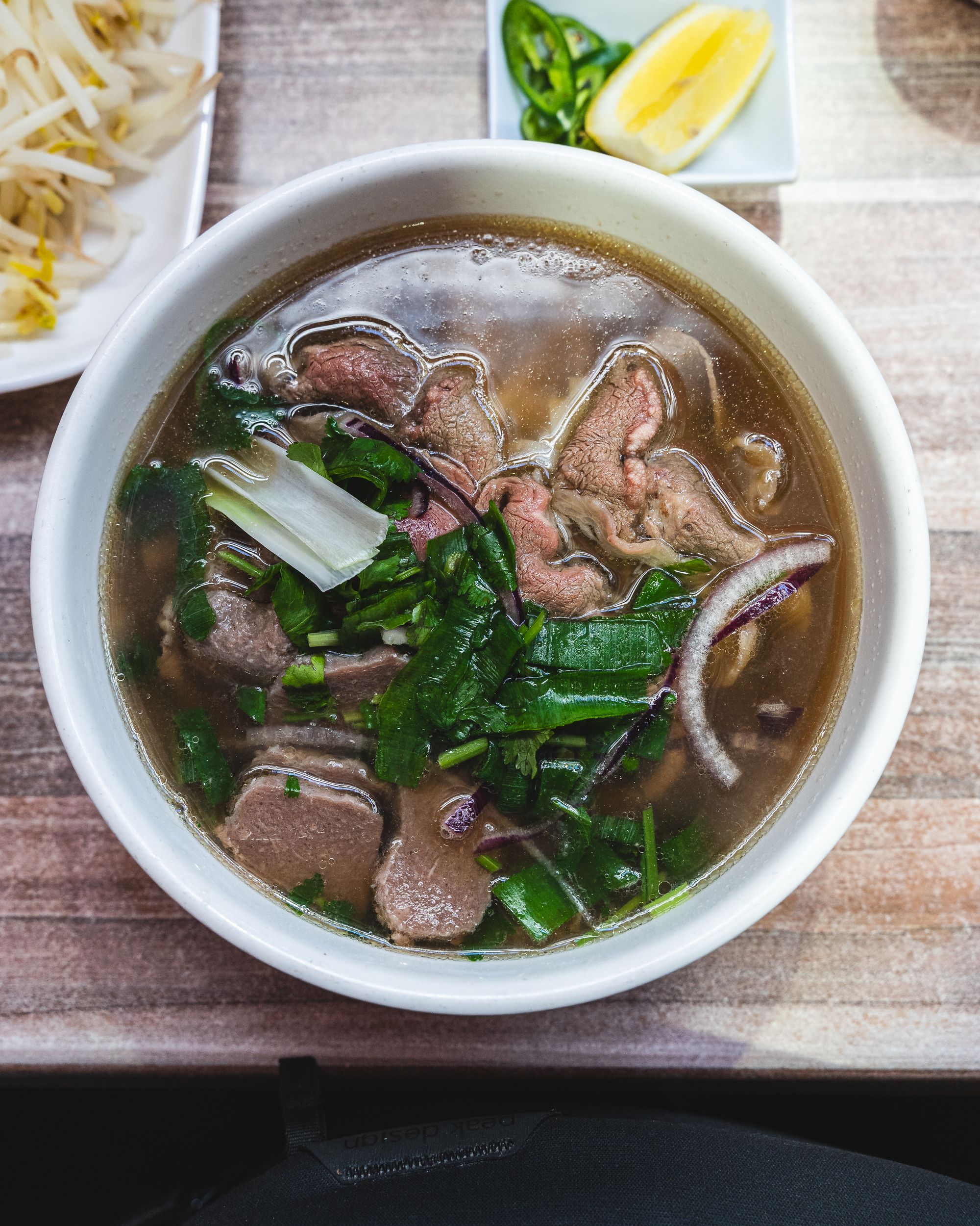 Top down shot of pho with beef slices, spring onions and beef balls