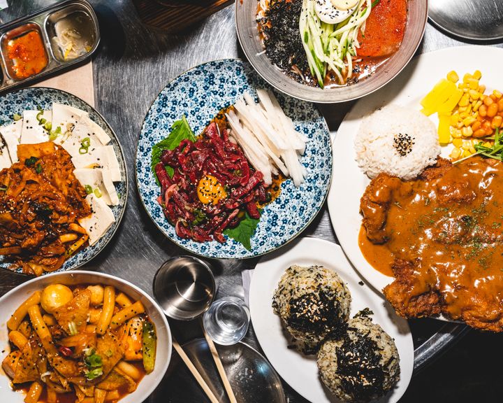 Top down shot showing a variety of Korean dishes on-top of a stainless steel table