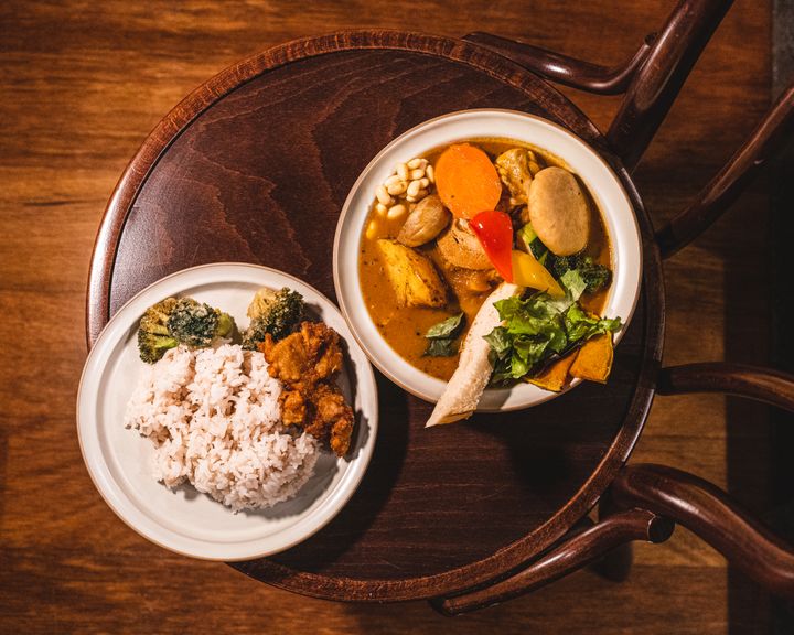 Top down shot of vegetable soup curry with a side of rice